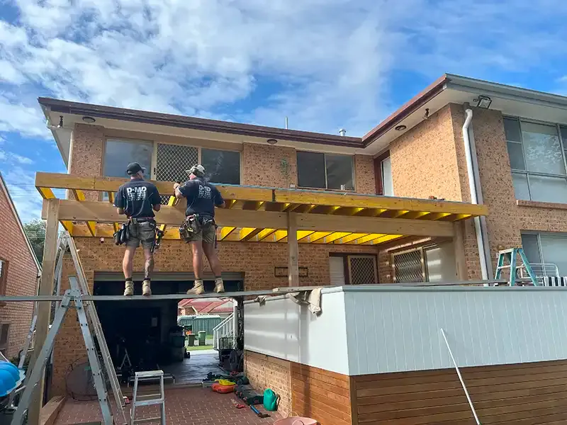 Decks of Distinction team building an elevated timber deck frame on a Central Coast home